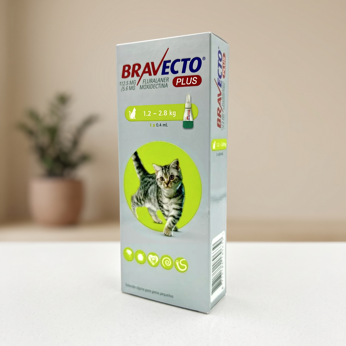 Bravecto Plus gato 1.2–2.8 kg, pipeta 0.4 mL — caja en una escena de hogar con fondo desenfocado